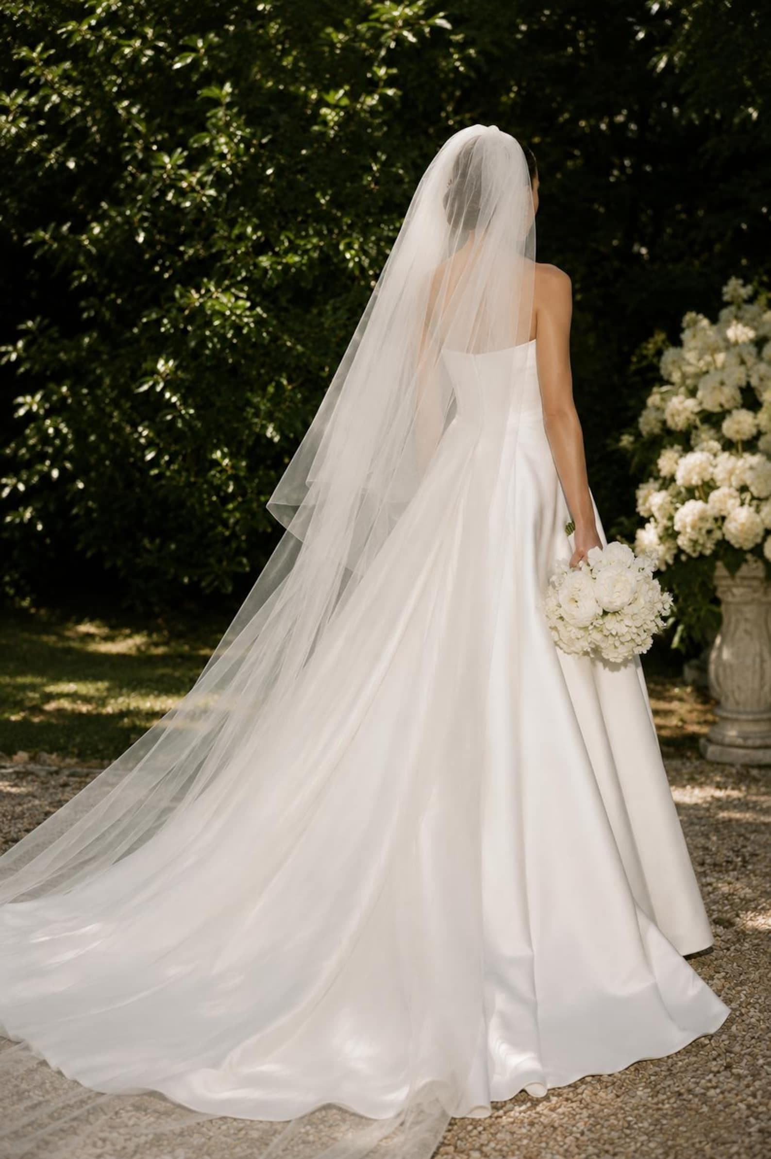 Bride in a garden wearing a cathedral length two-tier veil
